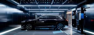 a sleek rideshare vehicle is showcased in a modern urban inspection centre on the gold coast, illuminated by bright artificial lights that highlight its polished exterior and professional inspection equipment surrounding it.
